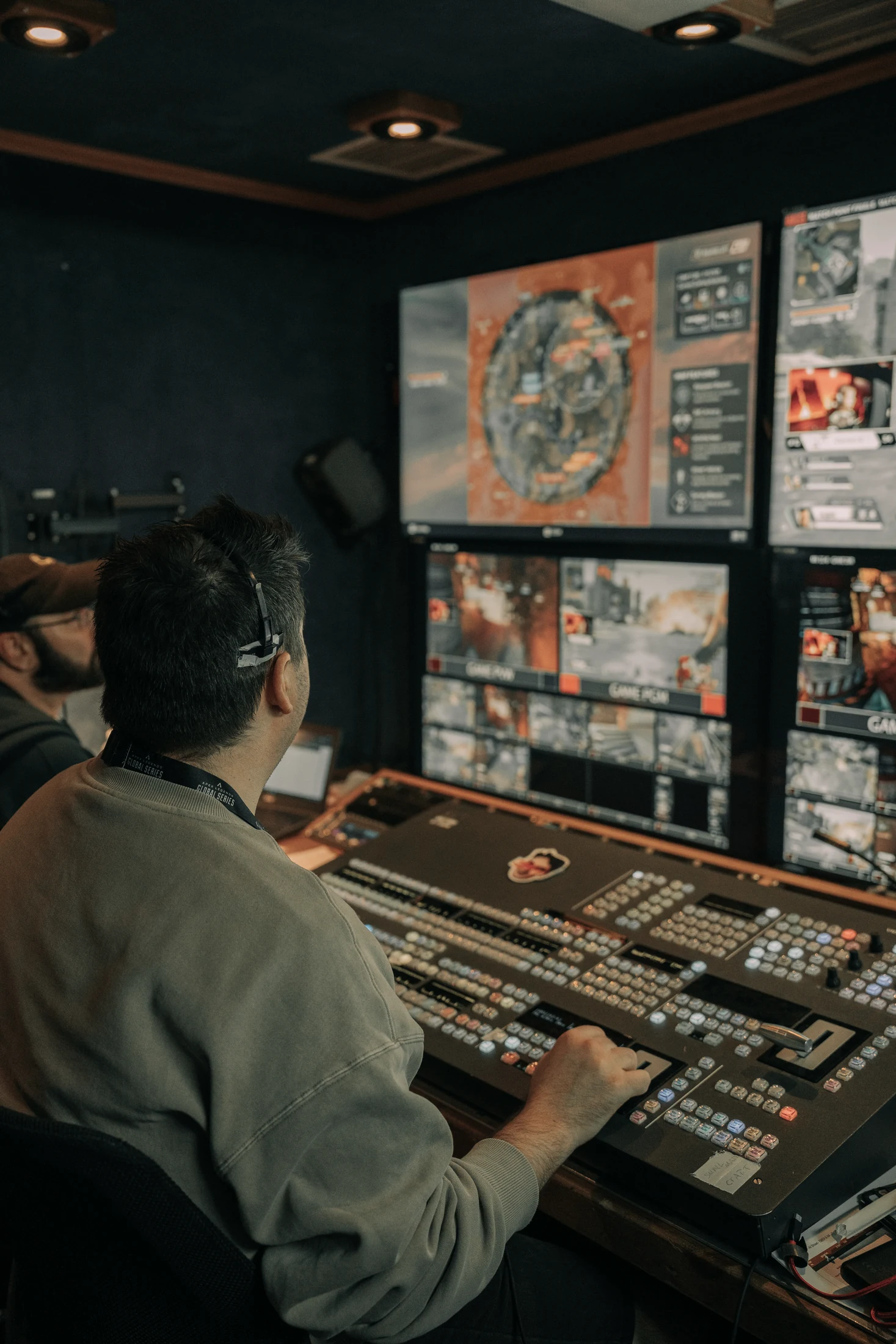 Tim Roots working at a broadcast production switcher in front of a monitor wall